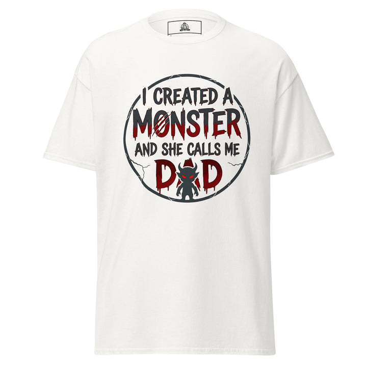 I Created A Monster And She Calls Me Dad funny graphic tee — horror style lettering with a small devil monster forming the A in DAD