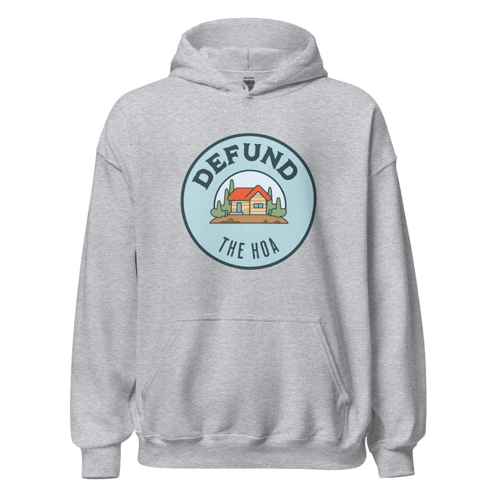 Defund The HOA funny suburban graphic tee — circular badge with cartoon house and trees and DEFUND THE HOA text